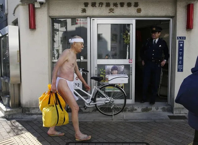 Eighty one-year-old Sakon Haba (L) wearing loin cloth walks past a police station after he bathed in ice-cold water at the Teppozu Inari shrine in Tokyo January 11, 2015. According to organizers, about 100 participants took part in the Shinto ceremony to purify their souls and wish for good health in the new year. (Photo by Toru Hanai/Reuters)