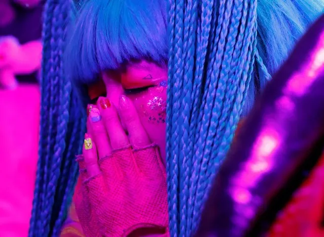 A staff members of Kawaii Monster Cafe called “Monster Girls” wipes her tears as she performs on the stage before the cafe ends its five-year run operation on the day, amid the coronavirus disease (COVID-19) outbreak, in Tokyo, Japan on January 31, 2021. A funky aesthetic of outlandish colors and designs made Kawaii Monster Cafe in the capital's youth culture hotspot of Harajuku a hit, drawing overseas A-listers, such as reality star Kim Kardashian, singer Dua Lipa and Jenny of K-pop's Blackpink. (Photo by Issei Kato/Reuters)