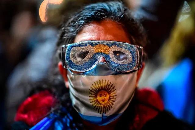 A demonstrator wears a face mask depicting an Argentinian flag during a protest against a judicial reform outside the court in Buenos Aires, on September 23, 2020. (Photo by Ronaldo Schemidt/AFP Photo)