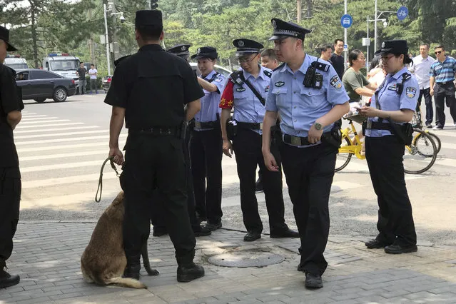 Chinese police officers gather after a motorcade including sedans, minibuses, motorcycles and a stretch limo with a golden emblem similar to one North Korean leader Kim Jong Un used previously was seen entering the Diaoyutai State Guesthouse in Beijing, China, Tuesday, June 19, 2018. Kim is making a two-day visit to Beijing starting Tuesday and is expected to discuss with Chinese leaders his next steps after his nuclear summit with President Donald Trump last week. (Photo by Ng Han Guan/AP Photo)