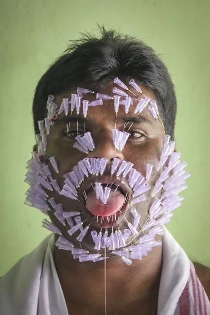 Bhupen Chandra Das poses for a photograph after inserting needles into his face and tongue at his house on March 18, 2015 in Assam India. A 38-year-old Indian man has taken to performing an extreme stunt of inserting needles into his face in a bid to enter record books. Bhupen Chandra Das, nicknamed as India's needle man, claims to hold a record for inserting as many as 550 surgical needles into his face. Das hails from north-eastern part of India and has been doing lethal stunts for the last 15 years. (Photo by Manash Gogoi/Barcroft India)