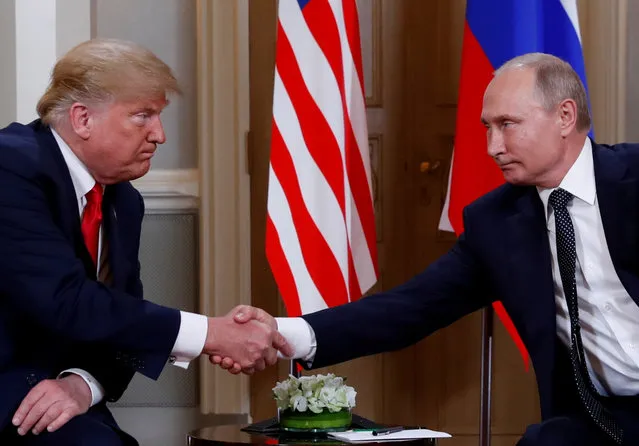 U.S. President Donald Trump and Russia's President Vladimir Putin shake hands as they meet in Helsinki, Finland July 16, 2018. (Photo by Kevin Lamarque/Reuters)