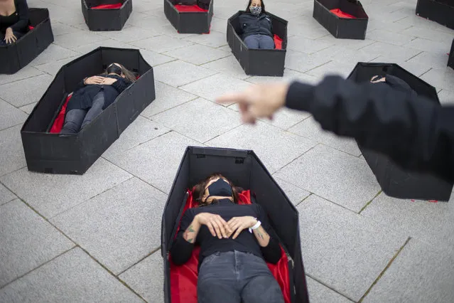 Women laying in coffins representing women killed in domestic violence during an event for upcoming International Women's Day in front of Tel Aviv's district court, Israel, Sunday, March 7, 2021. (Photo by Ariel Schalit/AP Photo)