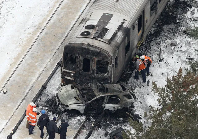 The burned out shell of an SUV, rests against a charred Metro-North Railroad commuter train as personnel from various agencies work the scene of a deadly accident in Valhalla, N.Y., Wednesday, February 4, 2015. (Photo by Frank Becerra Jr./AP Photo/The Journal News)