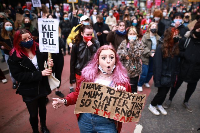 Protestors hold placards as they sit on the street during a Kill The Bill protest against the Police, Crime, Sentencing and Courts Bill, in Manchester, north west England on March 27, 2021. The police, crime, sentencing and courts bill would give police in England and Wales more power to impose conditions on peaceful protests, including those they deem to be too noisy or a nuisance to the community. Critics argue this infringes on the right to free and peaceful expression. (Photo by London News Pictures)