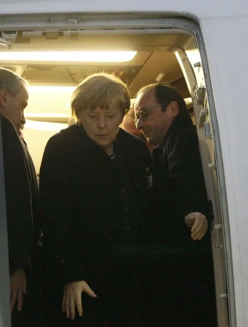 Germany's Chancellor Angela Merkel (C) and France's President Francois Hollande (R) walk out after a meeting inside a plane at an airport near Minsk, February 11, 2015. (Photo by Valentyn Ogirenko/Reuters)