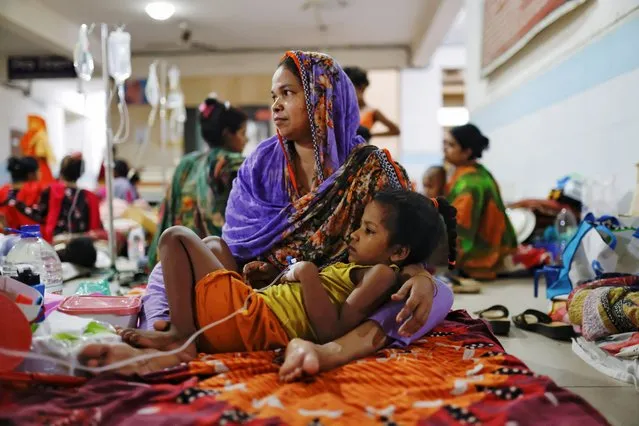 A dengue infected child lies on her mother's lap while receiving treatment at Mugda Medical College and Hospital in Dhaka, Bangladesh pn July 5, 2023. (Photo by Mohammad Ponir Hossain/Reuters)