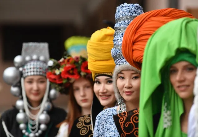 Models pose before the defile on the catwalk in front of the Opera House during the parade of models and designers during the opening of the World Nomad Fashion Festival in Bishkek on August 10, 2023. (Photo by Vyacheslav Oseledko/AFP Photo)