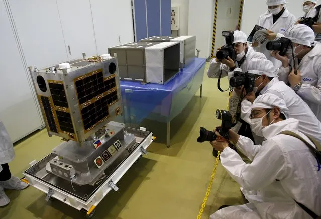 Photographers take pictures of DIWATA-1, Philippines' first micro satellite for multi spectral high precision earth observation, during a media tour at the Japan Aerospace Exploration Agency (JAXA) Tsukuba Space Center in Tsukuba, north of Tokyo, Japan, January 13, 2016. (Photo by Yuya Shino/Reuters)
