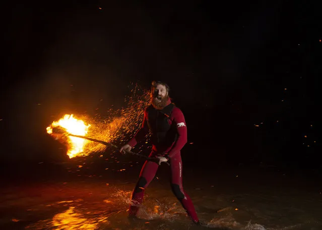 Pro surfer Al Mennie lights a beacon at Downhill strand as he completes his 100KM night swim for charity on March 1, 2021 in Portrush, Northern Ireland. Pro big wave surfer Al Mennie has completed his Surf Swim Through The Darkness challenge of swimming 100KM in the dark throughout the winter months in the North Atlantic ocean to raise awareness of depression and funds for the Aware charity which promotes mental health awareness. (Photo by Charles McQuillan/Getty Images)