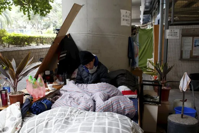 A street sleeper takes a nap under a bridge at a residential area in Hong Kong, China, January 23, 2016. Hong Kong Observatory said on Friday that temperatures will fall to around 6 degrees Celsius or below in the urban areas in a couple of days. (Photo by Bobby Yip/Reuters)