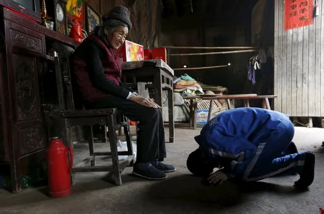 Chen Zhentai kowtows to his grandmother during a home visit from a drug rehabilitation centre, Hengmu village, Zhejiang province, March 18, 2015. Chen became an orphan after he lost his parents as a child and was raised by his grandmother. He was taken into rehab for using drugs for seven years and granted to visit his grandmother, Tu Xiufeng, 90, during a break with the company of police, according to local media. (Photo by William Hong/Reuters)
