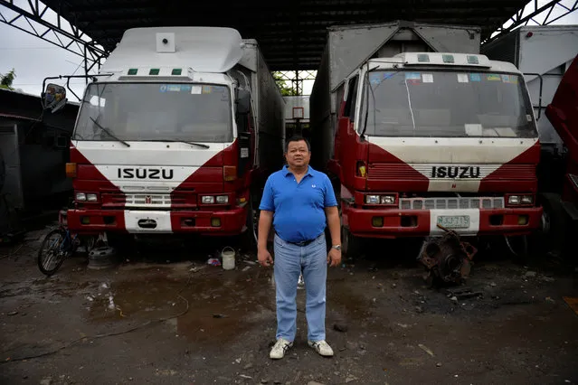 Jose Cecilia Jr., 51, poses for a photograph in front of trucks at a trucking company he owns in Santa Rosa, Laguna, south of Manila, Philippines December 2, 2016. “I give one hundred percent for Duterte. He's the only president who is fighting the drug lords and other syndicates in our country”, he said. (Photo by Ezra Acayan/Reuters)