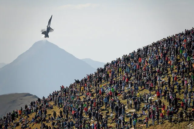 A F/A-18 Hornet fighter aircraft flies over spertators during the annual live fire event of the Swiss Air Force at the Axalp, over Brienz in the Bernese Alps on October 10, 2018. At an altitude of 2,200 meters above sea level, spectators attended a unique aviation display performed at the highest air force firing range in Europe. (Photo by Fabrice Coffrini/AFP Photo)