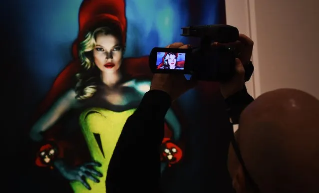 A journalist uses their phone to take a picture at the press preview for “Vogue 100: A Century of Style” exhibiting the photographs that has been commissioned by British Vogue since it was founded in 1916 at National Portrait Gallery on February 10, 2016 in London, England. (Photo by Stuart C. Wilson/Getty Images)