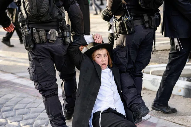Israeli policemen remove a member of the ultra-Orthodox Jewish community during a protest by the community against their conscription in the centre of Jerusalem on September 29, 2022. (Photo by Hazem Bader/AFP Photo)
