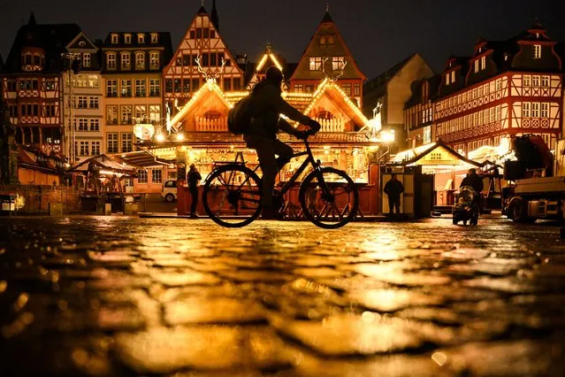 A person rides bicycle past recently installed Christmas decorations on the central square in Frankfurt am Main, western Germany, on November 21, 2023. (Photo by Kirill Kudryavtsev/AFP Photo)