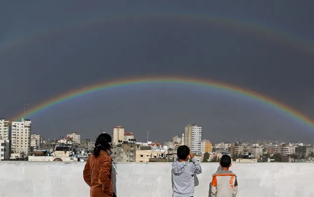 Palestinian children look at a rainbow shining over buildings after heavy rain poured in Gaza City, Thursday, December 12, 2013. The weather in Gaza dropped to 6 degrees Celsius (43 degrees Fahrenheit) with heavy rain showers and cloudy skies. (Photo by Hatem Moussa/AP Photo)