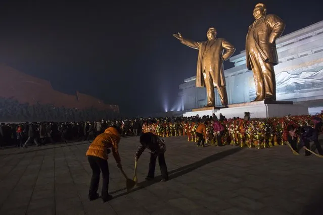 As North Koreans arrive to pay their respects, women sweep the base of statues of the late leaders Kim Il Sung and Kim Jong Il, right, in Pyongyang, North Korea, Monday, December 16, 2013, the eve of the second anniversary of the death of Kim Jong Il. (Photo by David Guttenfelder/AP Photo)