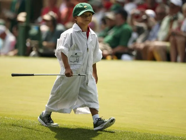 U.S. golfer Tiger Woods' son Charlie carries one of his father's clubs along the fourth hole during the par 3 event held ahead of the 2015 Masters at Augusta National Golf Course in Augusta, Georgia April 8, 2015. (Photo by Phil Noble/Reuters)