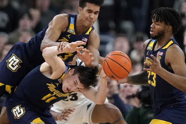 Marquette guard Tyler Kolek (11), forward Oso Ighodaro (13) and forward David Joplin (23) try to gain control the ball during the second half of the team's NCAA college basketball game against Providence, Tuesday, December 19, 2023, in Providence, R.I. (Photo by Steven Senne/AP Photo)