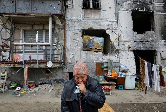 Local resident Galina Shevtsova reacts outside the apartment building where she lives in the basement with her husband Pavel after their flat was destroyed in March 2022 in the course of Russia-Ukraine conflict, in Mariupol, Russian-controlled Ukraine on November 16, 2022. (Photo by Alexander Ermochenko/Reuters)