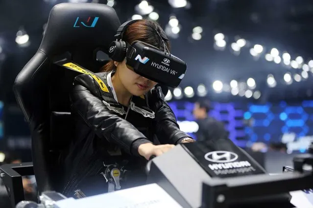A visitor tries out a Hyundai virtual reality simulator at the 16th Shanghai International Automobile Industry Exhibition in Shanghai, China, 20 April 2015. (Photo by How Hwee Young/EPA)