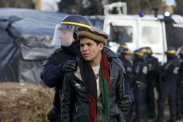 A French CRS riot policeman apprehends a young Afghan during a protest by migrants against the partial dismantlement of the camp for migrants called the “Jungle”, in Calais, northern France, February 29, 2016. (Photo by Pascal Rossignol/Reuters)
