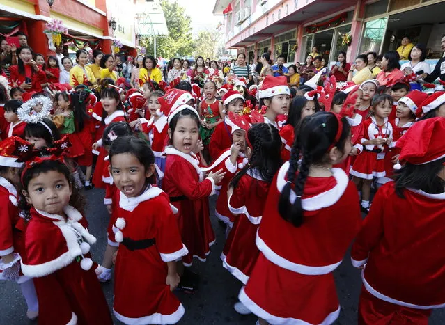Thai students dressed as Santa Claus congregate during Christmas celebrations with elephants at a school in the world heritage city of Ayutthaya, north of Bangkok, Thailand, 24 December 2018. The annual event is held every year for to celebrate the upcoming Christmas festive season and promote tourism in Ayutthaya. (Photo by Narong Sangnak/EPA/EFE)