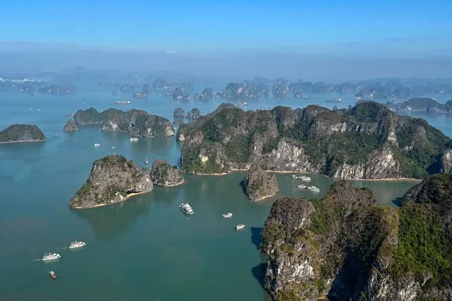 This aerial photo taken from a seaplane shows tourist boats sailing on the waters of Ha Long Bay in Vietnam's northeastern province of Quang Ninh on December 28, 2023. Vietnam's Ha Long Bay is losing its famous turquoise hue as pollution and over-development threatens wildlife and its picture-perfect image. (Photo by Nhac Nguyen/AFP Photo)