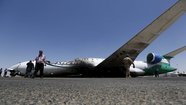 Airport officials gather near a Felix Airways plane, destroyed by an airstrike, at the international airport of Yemen's capital Sanaa April 29, 2015. Jets from a Saudi-led alliance destroyed the runway of Yemen's Sanaa airport on Tuesday to prevent an Iranian plane from landing there, Saudi Arabia said, as fighting across the country killed at least 30 people. (Photo by Khaled Abdullah/Reuters)