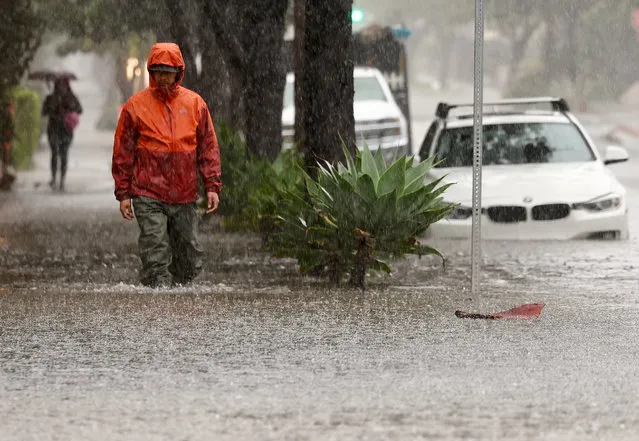 A person walks along a flooded street as a powerful long-duration atmospheric river storm, the second in less than a week, impacts California on February 4, 2024 in Santa Barbara, California. The storm is delivering potential for widespread flooding, landslides and power outages while dropping heavy rain and snow across the region.  (Photo by Mario Tama/Getty Images)