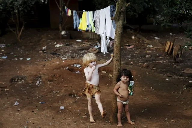 Guarani Indian boys stand in the village of Pyau at Jaragua district, in Sao Paulo April 27, 2015. More than 700 Guarani Indians live in three villages in the Jaragua district in Sao Paulo. (Photo by Nacho Doce/Reuters)
