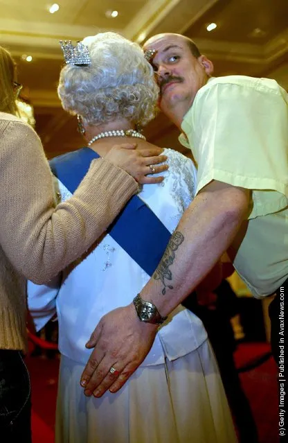 Tourist Nick Travis pats the behind of a new waxwork model of the Britain's Queen Elizabeth