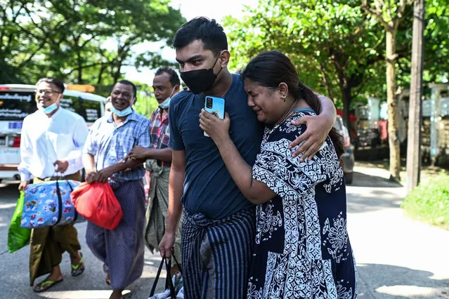 A man celebrates with relatives after being released from Insein Prison in Yangon on October 19, 2021, as authorities released thousands of people jailed for protesting against a February coup that ousted the civilian government. (Photo by AFP Photo/Stringer)
