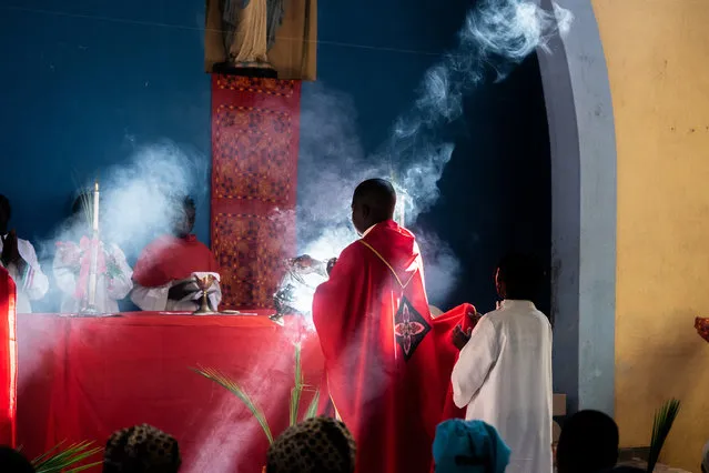 Father Celso Taibo burns incense during a palm Sunday mass on April 14, 2019 at Lady of Grace Parish Catholic Church in Barrio Manasse, Buzi District, Sofala Province, Mozambique. Congrats marched the streets of Buzi town skipping rubbles to pass huge fallen trees and buildings with no roofs, windows or doors, one month following the cyclone Idai that killed more than 600 people and displaced 150 000 people in Mozambique. (Photo by Zinyange Auntony/AFP Photo)