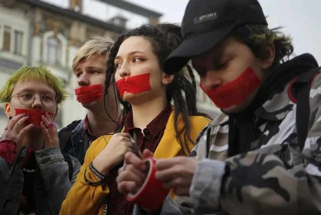 Activists of a local LGBT community put tape over their mouths as they protest against discrimination in Saint Petersburg, Russia April 17, 2019. (Photo by Anton Vaganov/Reuters)