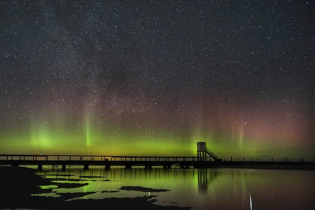 The Northern Lights and the Milky Way above the refuge hut on Monday March 15, 2021, where Holy Island in Northumberland is linked to the mainland by a long causeway where twice each day the incoming tide covers the road. Safe crossing times are displayed for motorists but when drivers get caught out they can take refuge in the hut and be rescued or wait for the next low tide. (Photo by Owen Humphreys/PA Images via Getty Images)