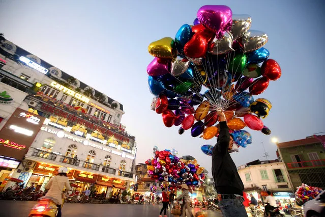 People sell colorful balloons at a street in Hanoi, Vietnam, 13 February 2017. Valentine's day has become very popular in Vietnam in recent years, as a way to express love, especially among teenagers. (Photo by Luong Thai Linh/EPA)