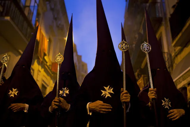 Hooded penitents from “El Valle” brotherhood take part in a traditional annual procession in Seville, Spain, Thursday, March 24, 2016. (Photo by Francisco Seco/AP Photo)