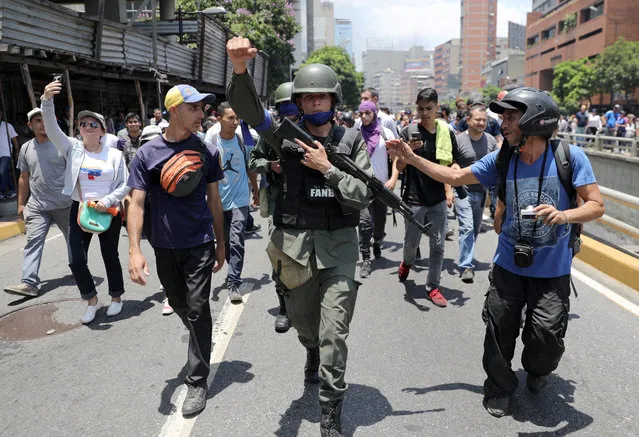 A Venezuelan National Guard member gestures, after joining anti-government protesters in a march, showing his support for opposition leader Juan Guaido in Caracas, Venezuela April 30, 2019. (Photo by Manaure Quintero/Reuters)