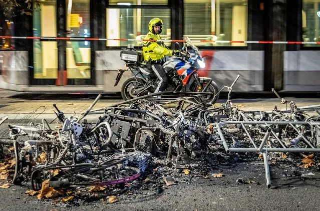 A policeman looks at damage caused after a protest against the '2G policy' turned into riots, Rotterdam, Netherlands, early 20 November 2021. Hundreds of demonstrators staged a protest on the night of 19 November that turned into riots, with fireworks being set off and police firing multiple warning shots. The protest was staged to protest against the 2G policy, which refers to the two Dutch words for vaccinated and recovered. (Photo by Jeffrey Greenweg/EPA/EFE)