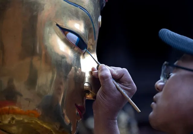 A Nepalese man paints the eye of Lord Buddha before the procession of the Samyak Mahadan festival in Patan, Nepal, 13 March 2024. Thousands of devotees observed the two-day-long Samyak Mahadan, an alms-giving festival offering worship at the painted idol of Lord Buddha, brought from various temples, for world peace and human welfare. Devotees offer different gifts to the deities, monks, and Buddhist communities, including money, food, and rice, during this festival, which is observed every five years. (Photo by Narendra Shrestha/EPA/EFE)