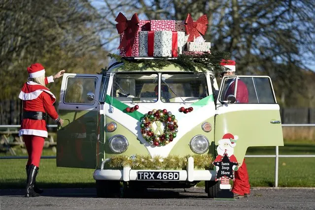 Jo (left) and Scott Forbes from Dorset add Christmas decorations to their 1966 Type 2 Split Screen VW California during the New Forest VW Santa Run at Beaulieu Motor Museum on Sunday, November 28, 2021. The event, which is open to all classic and custom VWs, raises funds for the Piam Brown unit at Southampton General Hospital. (Photo by Andrew Matthews/PA Images via Getty Images)