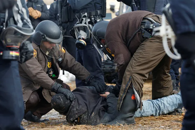 Police detain a protester in the main opposition camp against the Dakota Access oil pipeline near Cannon Ball, North Dakota, U.S., February 23, 2017. (Photo by Terray Sylvester/Reuters)