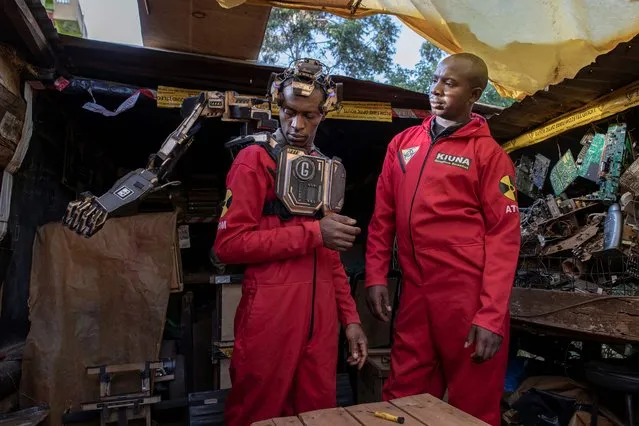 David Gathu (L), 30, and Moses Kiuna (R), 29, both self-taught innovators, demonstrate the operation of a bio-robotic prosthesis using brain-signals created using salvaged electrical components, mechanical parts, plywood and rubber bits at their makeshift laboratory at Thogoto village in Kikuyu municipality, Kiambu county, on January 31, 2023. Cousins Moses Kiuna, 29, and David Gathu, 30, created their first prosthetic arm in 2012, after their neighbour lost a limb to an industrial accident. But their latest invention is a significant upgrade. The device uses a headset receiver to pick up brain signals and convert them to an electric current, which is then sent to a transmitter that wirelessly relays commands to the arm, prompting it into action. (Photo by Tony Karumba/AFP Photo) 