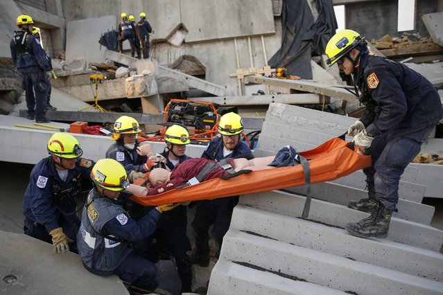 Rescue specialists for USA-1 carry a victim rescued from the scene of a mock disaster area during a training exercise at the Guardian Center in Perry, Georgia, March 25, 2014. (Photo by Shannon Stapleton/Reuters)