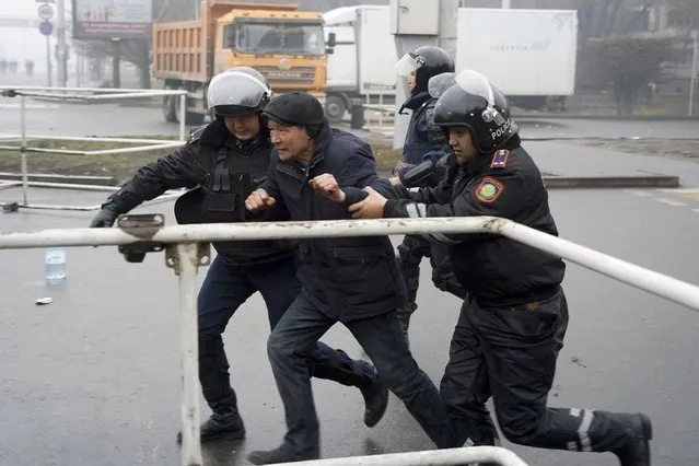 Police officers detain a demonstrator during a protest in Almaty, Kazakhstan, Wednesday, January 5, 2022. Demonstrators denouncing the doubling of prices for liquefied gas clashed with police in Kazakhstan’s largest city and held protests on Tuesday in about a dozen other cities in the country. (Photo by Vladimir Tretyakov/AP Photo)