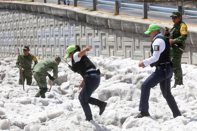 Security forces and soldiers try to clear away ice after a heavy storm of rain and hail which affected some areas of the city in Guadalajara, Mexico on June 30, 2019. Photo by Fernando Carranza/Reuters/Todos los Derechos Reservados)