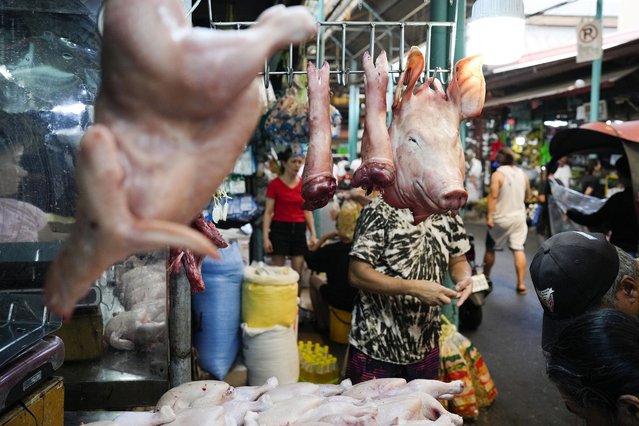 A meat vendor counts money at a public market in Marikina, Philippines on Wednesday, April 24, 2024. (Photo by Aaron Favila/AP Photo)